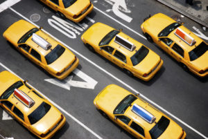 Fleet of yellow taxi cabs make their way down the street of Broadway in New York City in view from above
