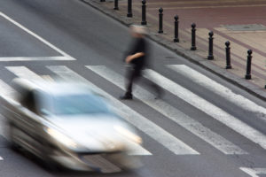 Pedestrian and a driving car on zebra crossing