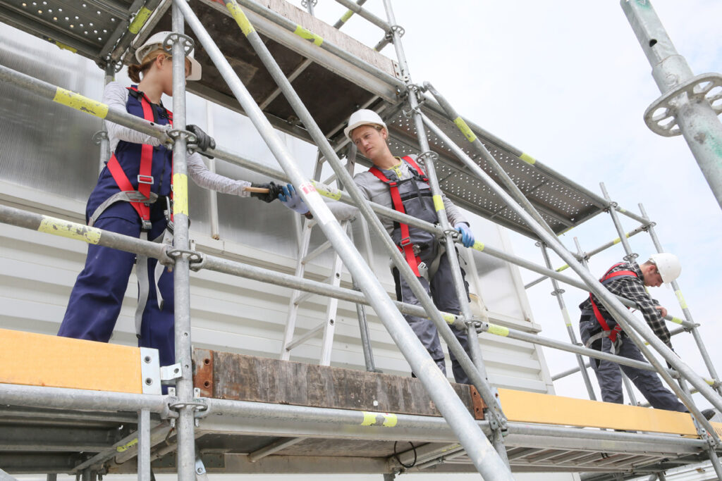 Construction workers installing scaffolding