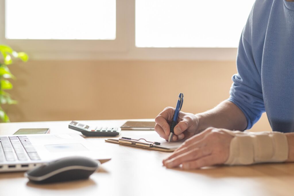 man with wrist brace reading paperwork