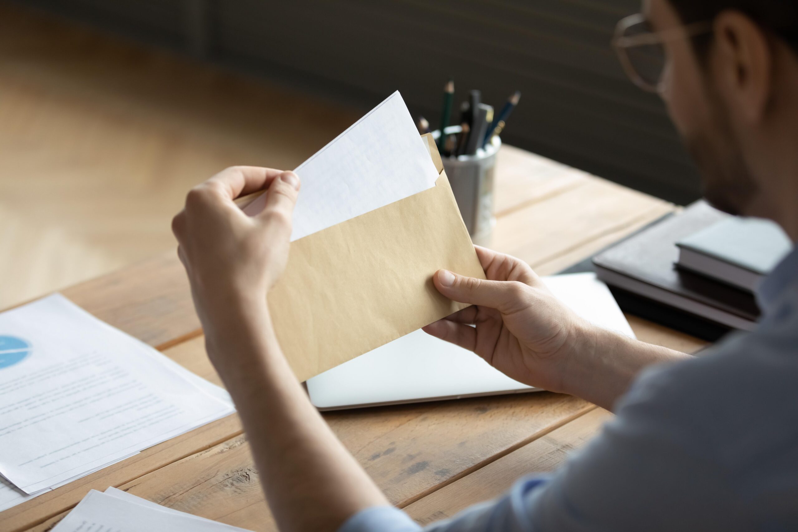 worker reading insurance letter at home