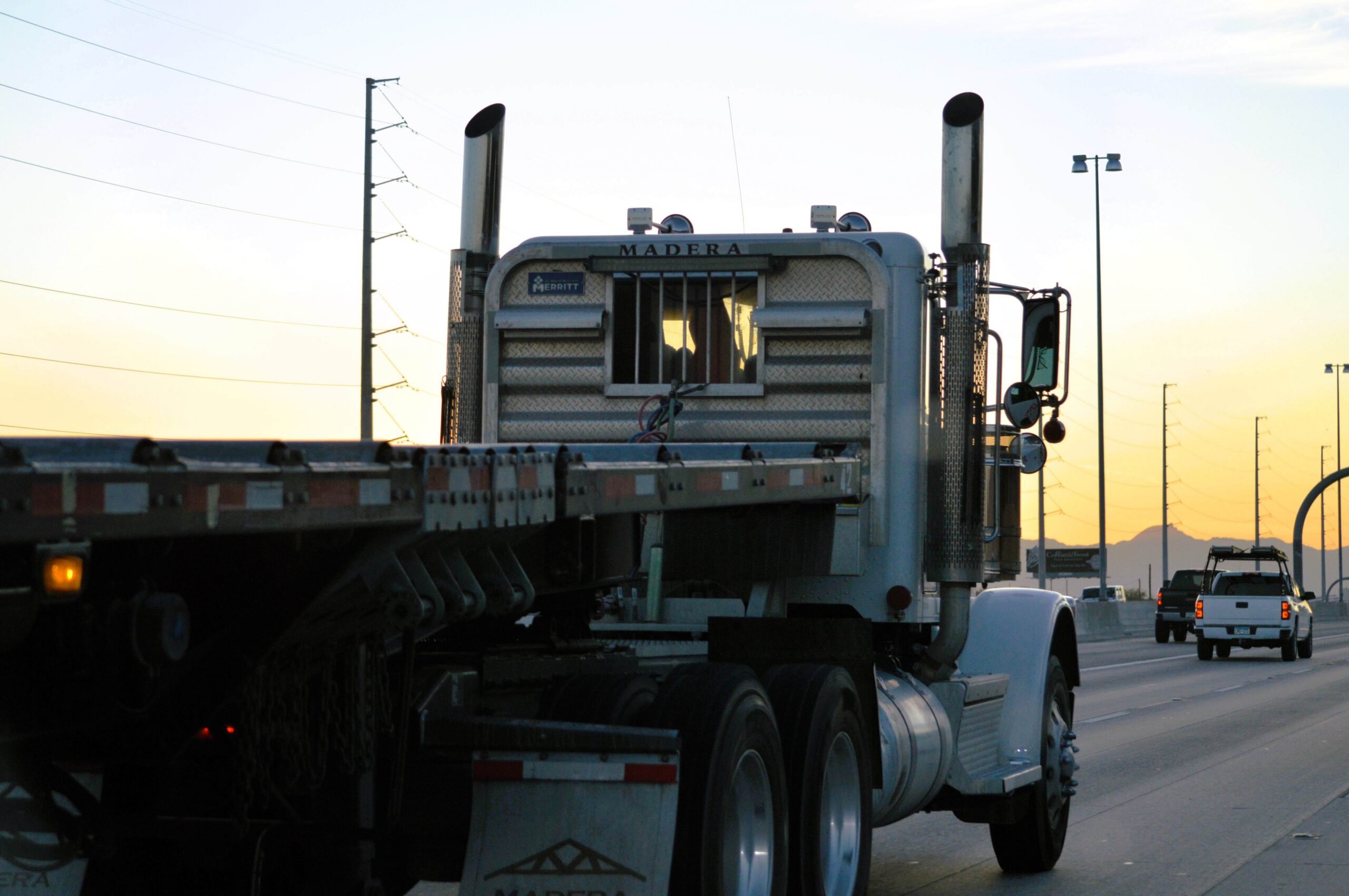 Semi-truck driving on a highway at dusk
