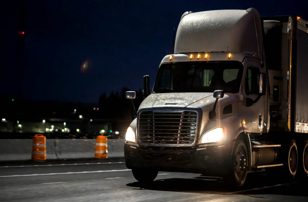 Semi-truck headlights on an interstate at night