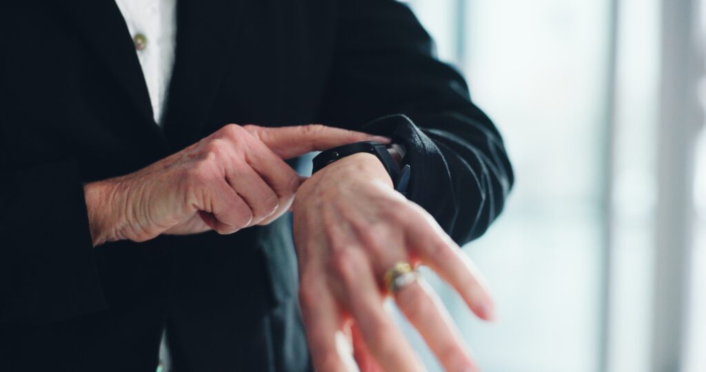 Worker's hand punching a time card at a time clock